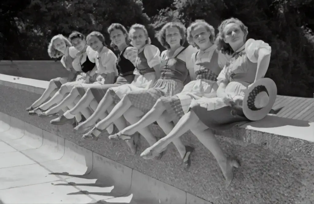 A group of women perched on a ledge.