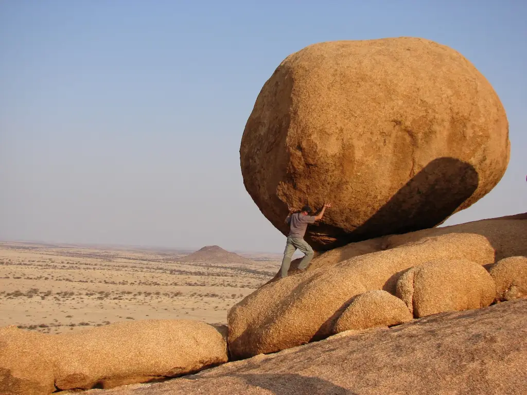 Keywords: man, climbing, large rock, desert.