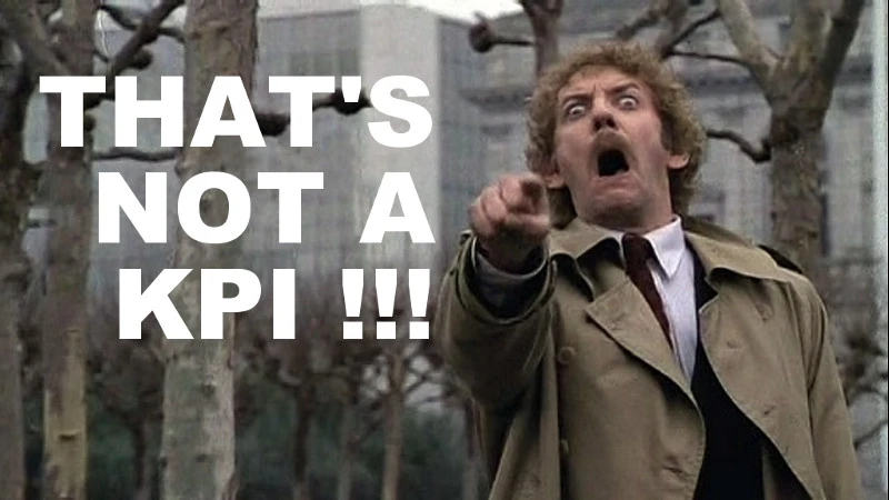 Person in a trench coat with a surprised expression pointing forward, accompanied by large text: "THAT'S NOT A KPI!!!.
