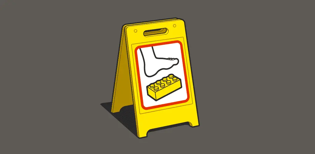Yellow caution sign with an image of a foot stepping on a toy brick.